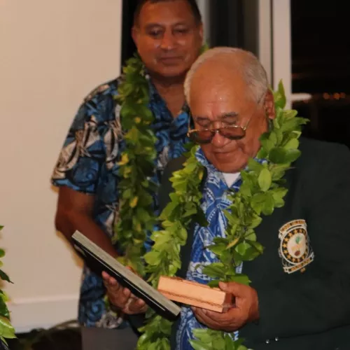 Tutai Toru receives his pioneer award from Prime Minister Henry Puna with King's Representative, His Excellency Sir Tom Marsters in the background, August 2019.